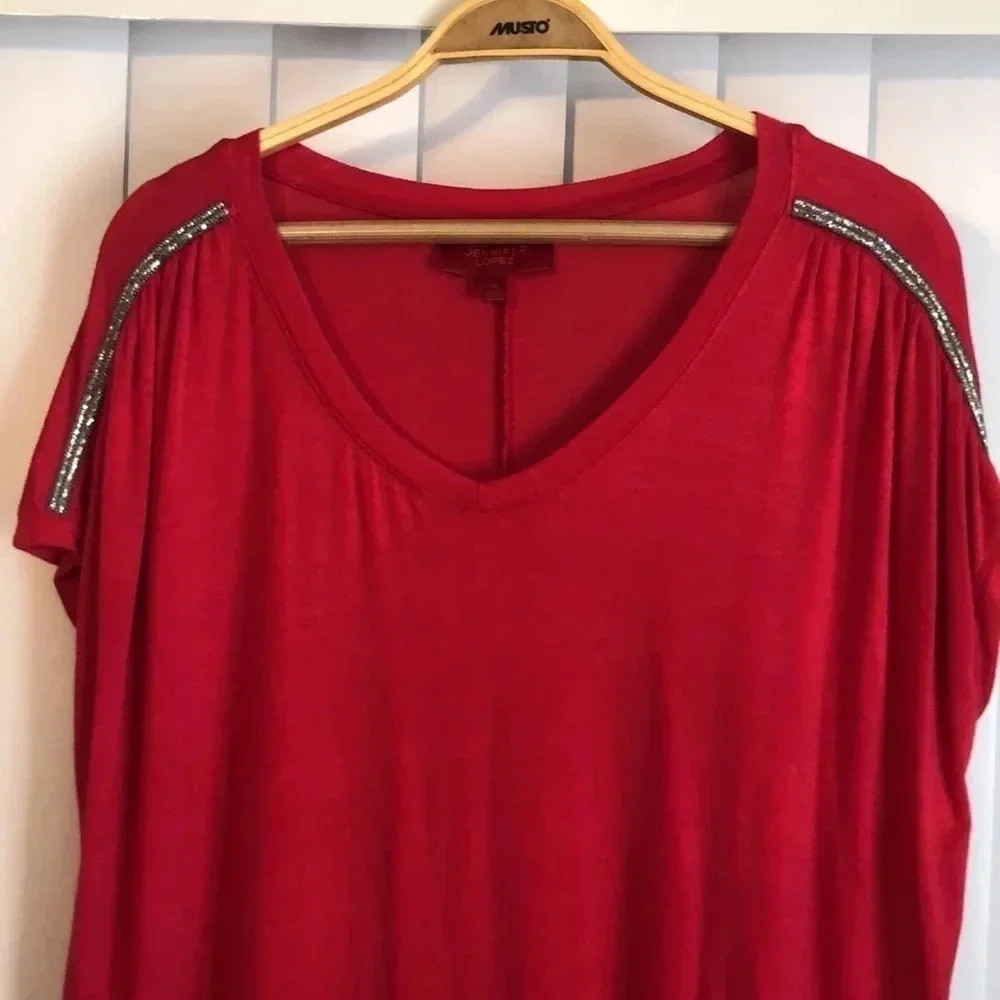 Jenifer Lopez red top with sparkly shoulder line.